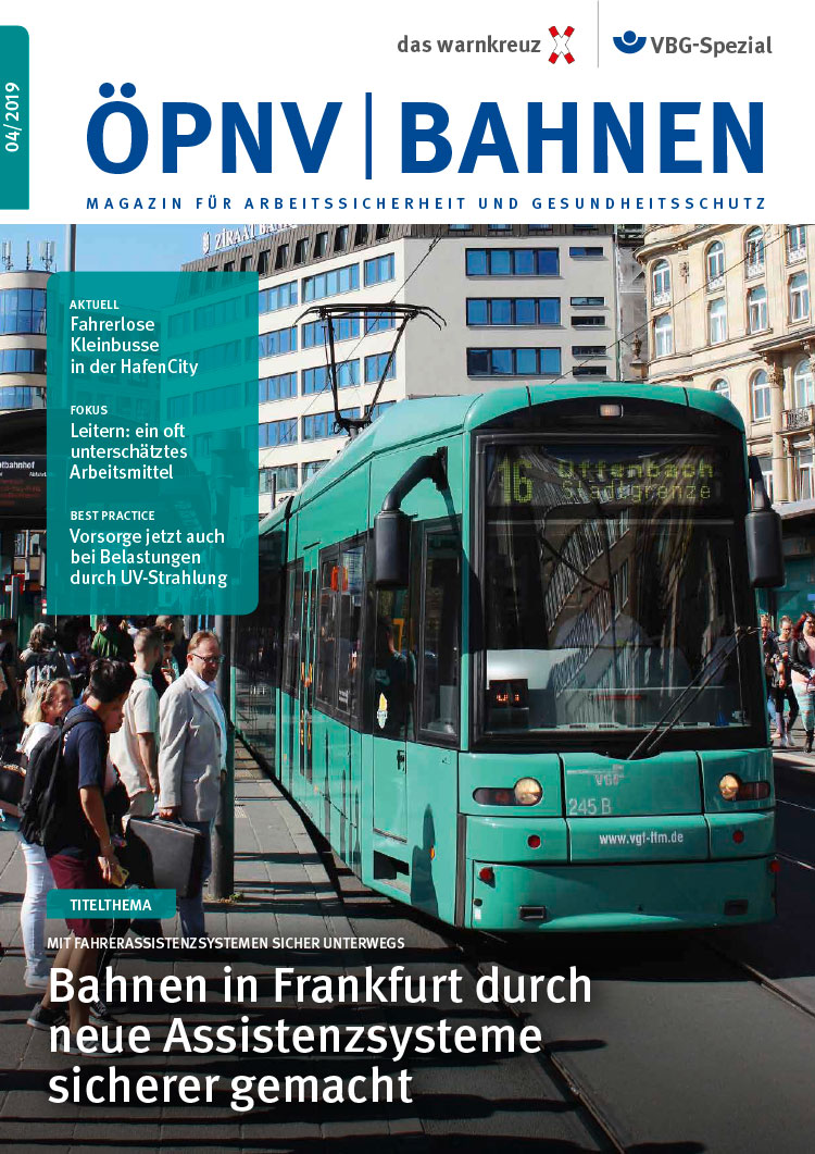 Magazin-Cover: Eine grüne Straßenbahn fährt über einen Übergang, vor dem mehrere Passanten warten